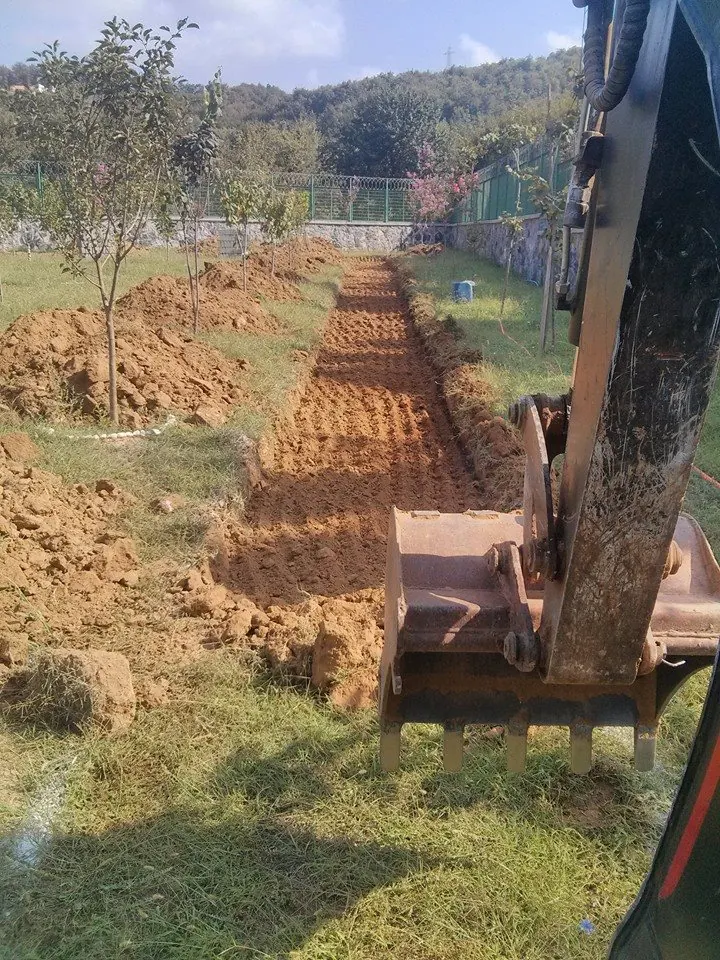 Yeşil alanda açılmış kanal hattı ve makine kovası