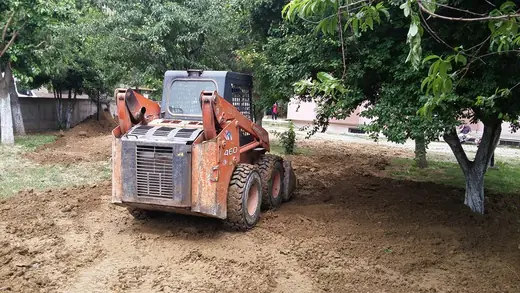 Ağaçlık alanda çalışan mini kepçe (kompakt yükleyici)