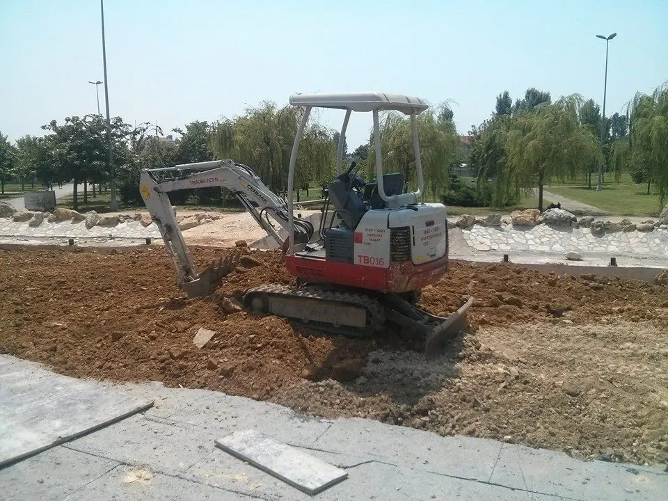 Park alanında kazı yapan paletli mini ekskavatör
